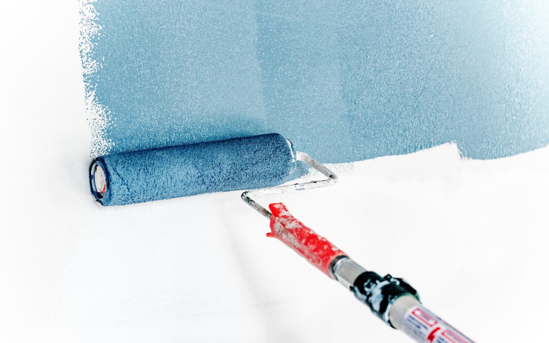 what to consider before hiring a painter in Surrey - blue rolling brush on a whitewall